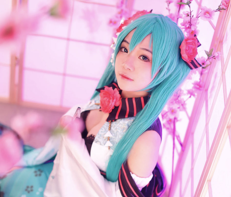 Cosplay model dressed in pink and black with long blue hair