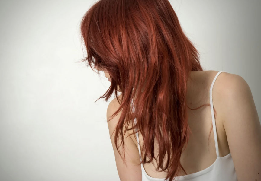 Woman with long red hair facing away from the camera
